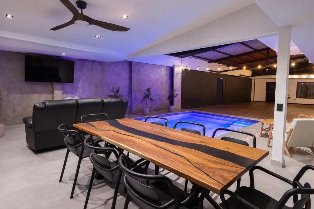 Outdoor dining and lounge at night at Palma Roots Villa, Jaco Beach, Costa Rica